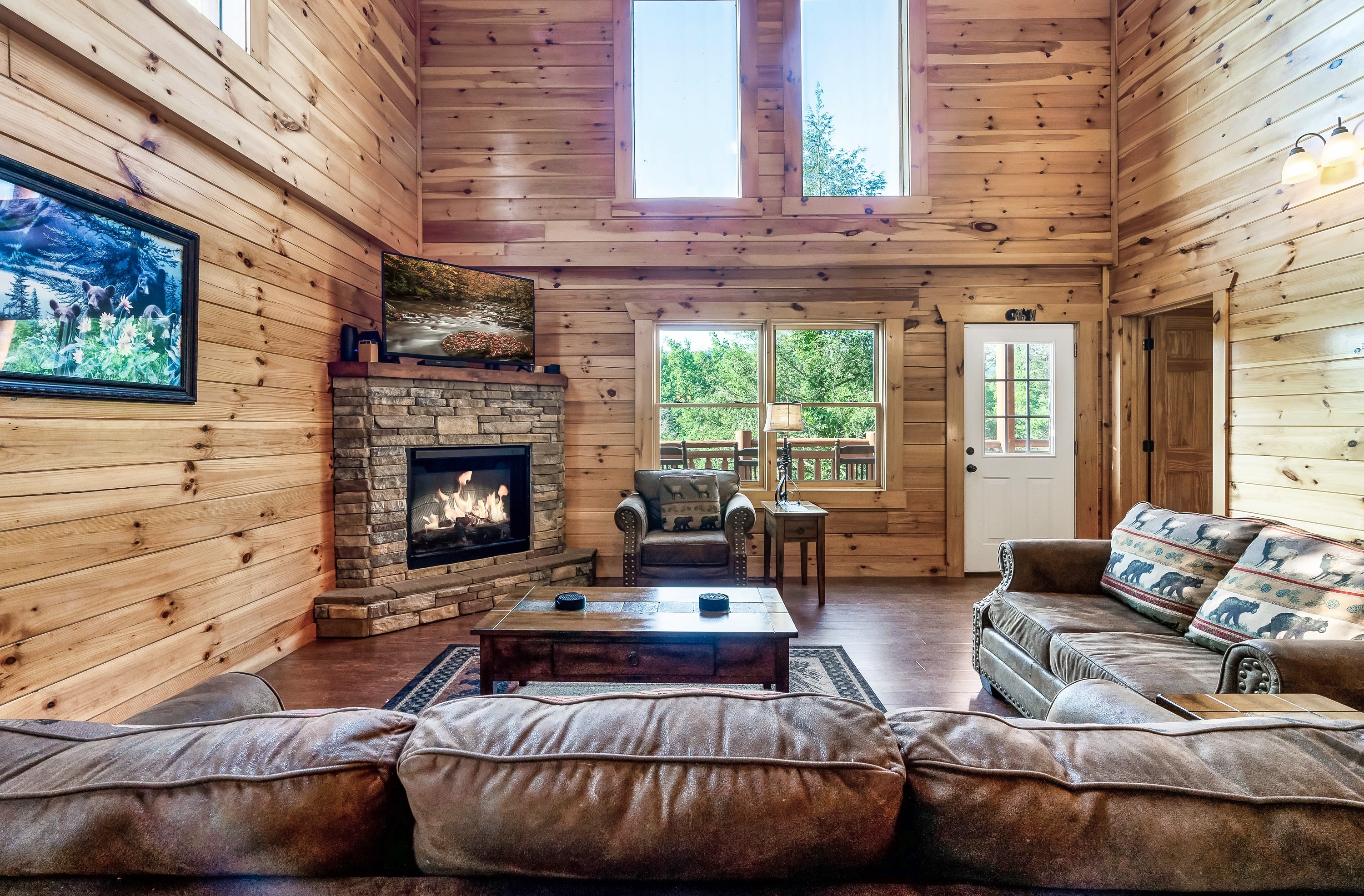 Vaulted living room with stone fireplace and mountain views
